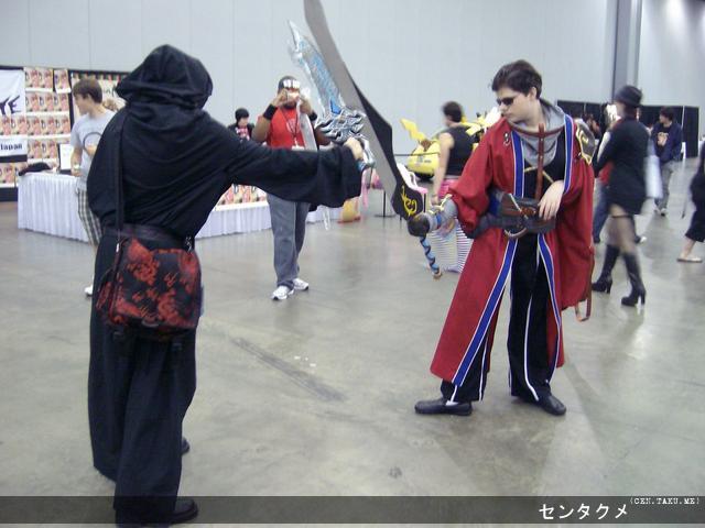 Sir Auron from Final Fantasy X engaging in a battle with another cosplayer.